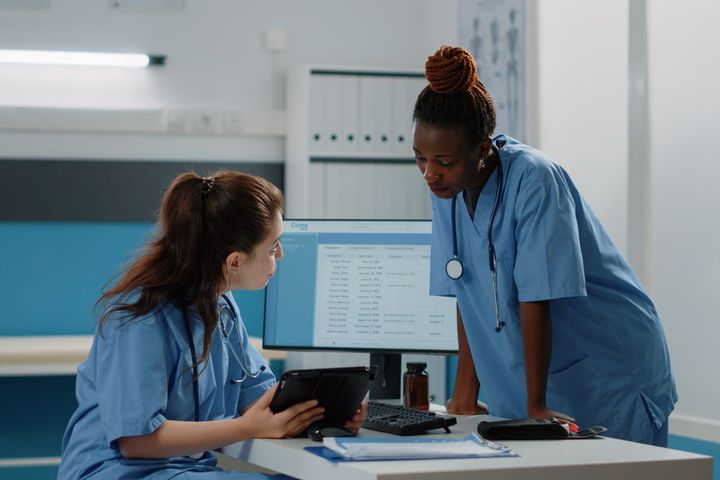 Arkansas nurses discuss a patient's chart.