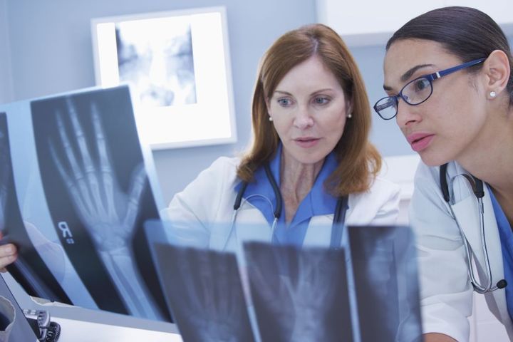 A physician assistant and her supervising physician go over a patient's X-rays.