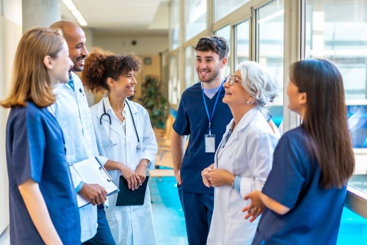 A group of doctors and nurses gather for an informal meeting.
