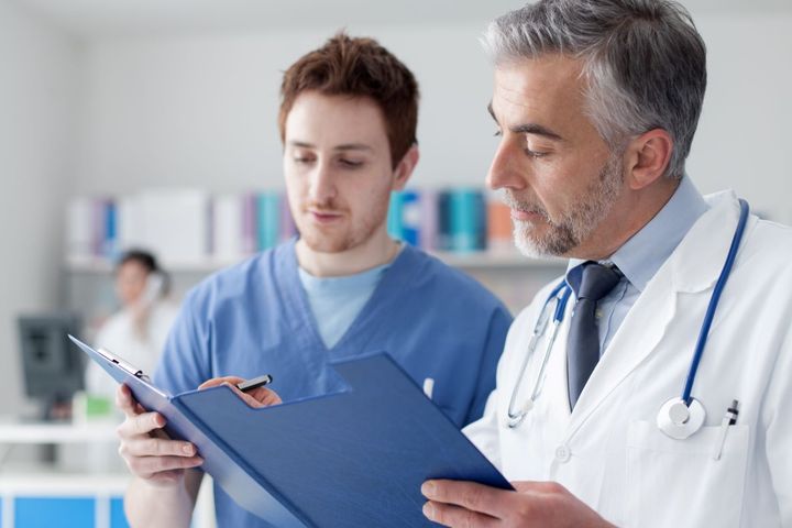 A certified medical assistant (CMA) helps a physician with patient records.
