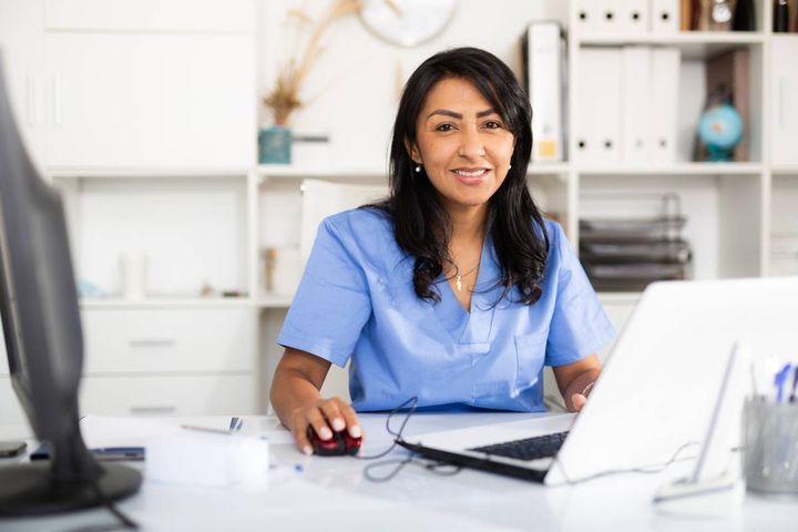 A healthcare professional with CHESP certification works on the computer.