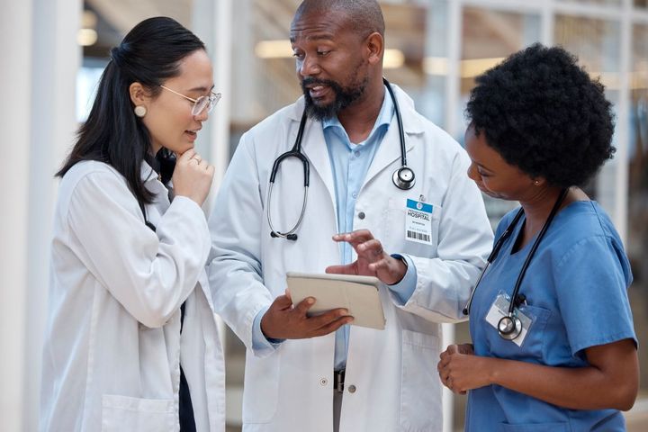 A hospital's clinical operations manager meets with a nurse and a physician.