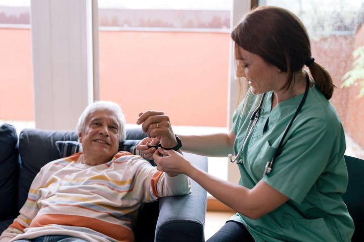 Clinician helping patient put on wearable technology in a healthcare facility