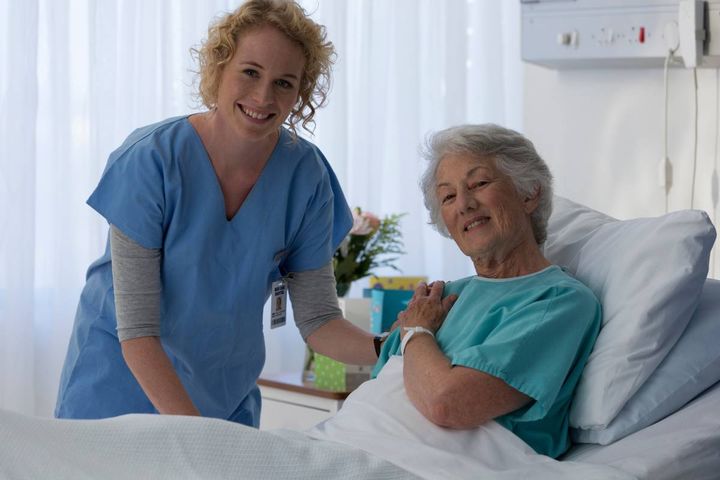 A nurse with CNN certification assists a patient in a hospital room.