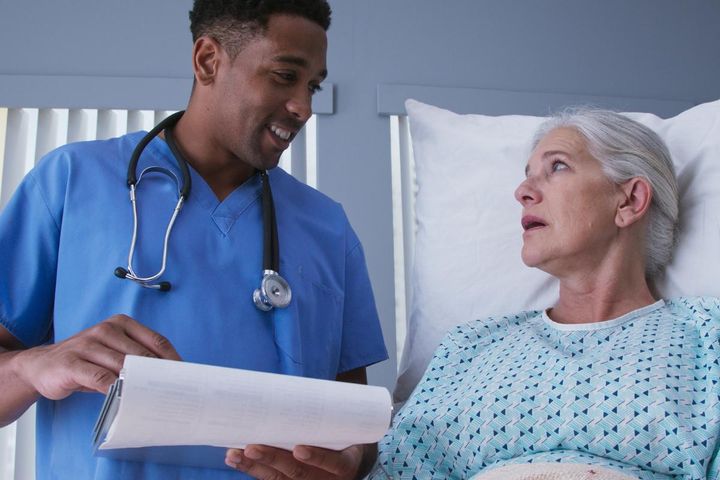 A critical care nurse practitioner meets with a patient to discuss their care plan.