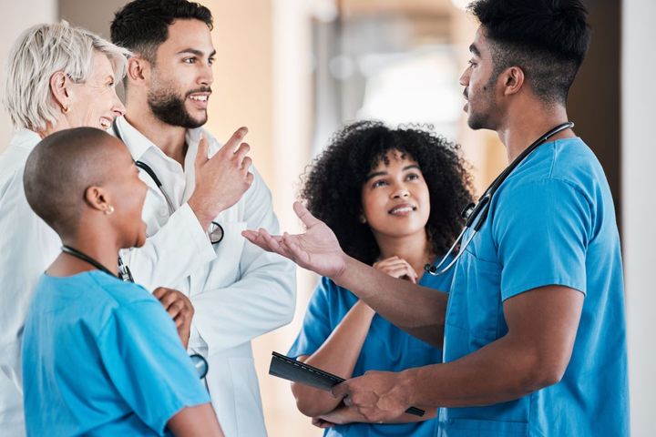 A diverse group of nurses and physicians have a discussion.