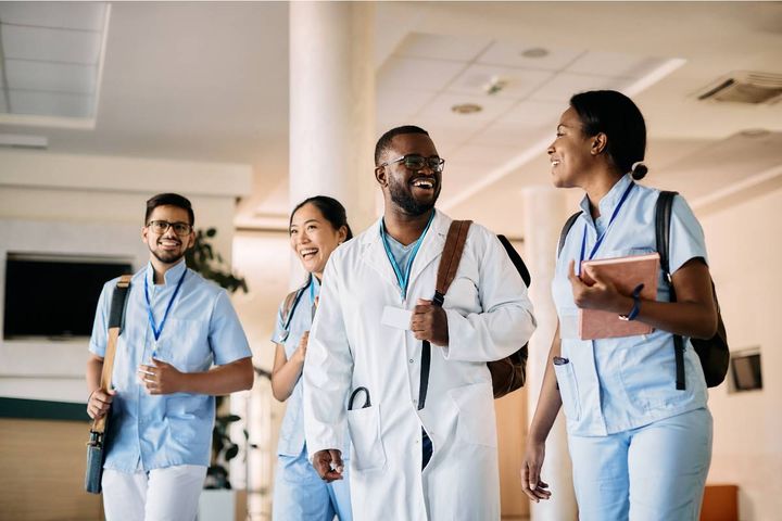 A group of students discuss the Dorothy Johnson nursing theory after a class.