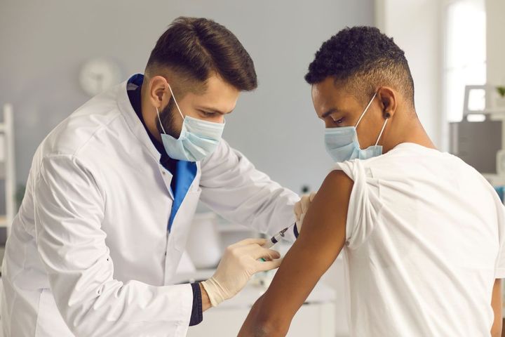 A physician administers a vaccination to a patient.