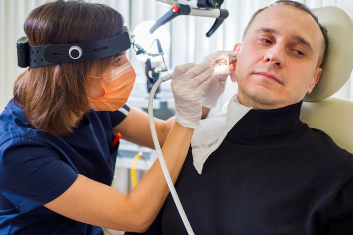An ENT nurse checks a patient's ear.