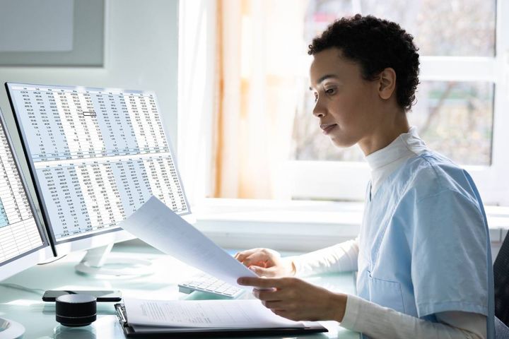 A nurse reviews her documents as she practices financial planning for nurses.