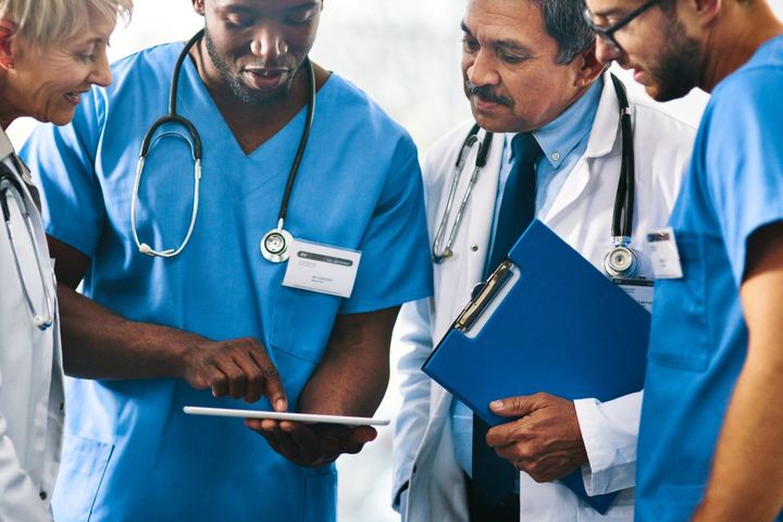 A team of healthcare workers discuss a patient case.