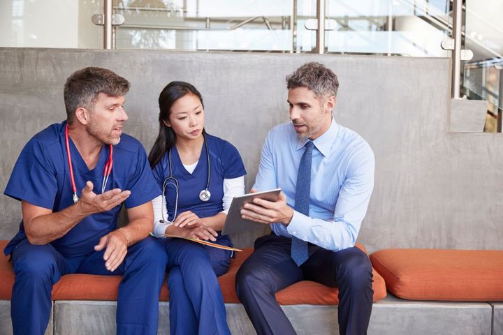 Two nurses discuss ways to respond to a healthcare cyber attack with their IT consultant.