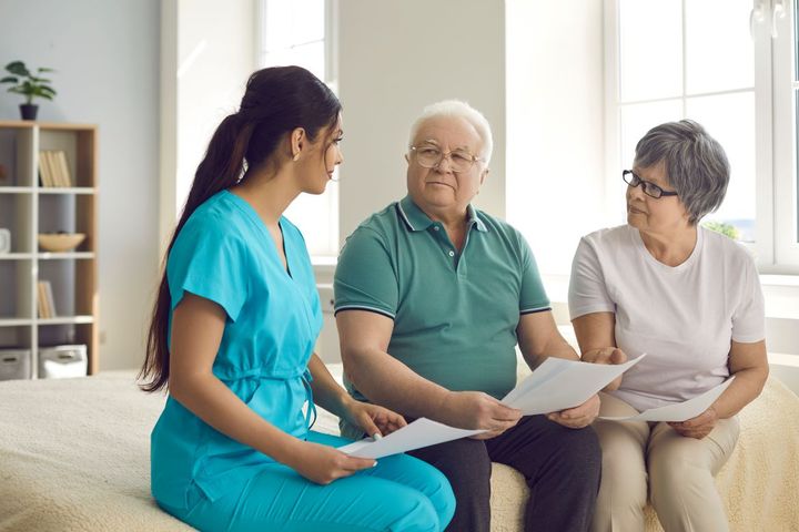 A nurse goes over various healthcare payment models with a patient and his wife.