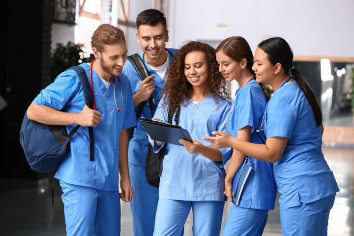 A group of students reviews the history of nursing timeline on their way to class.
