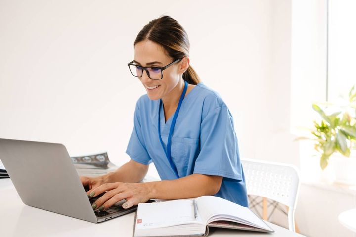 A nurse researches how to become an RN in Louisiana on the computer.
