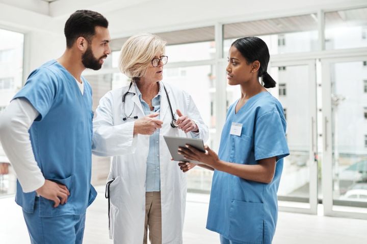 Two nurses and a physician discuss the treatment for a patient.