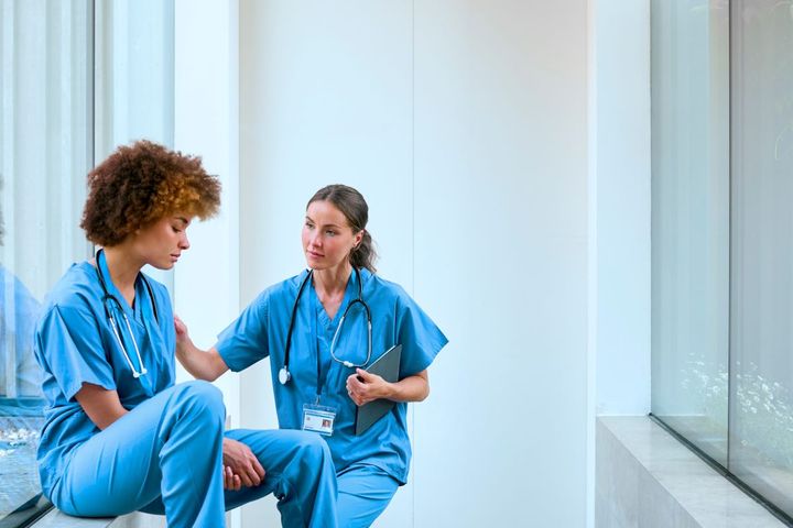 A nurse comforts one of her colleagues who is grieving the loss of a loved one.