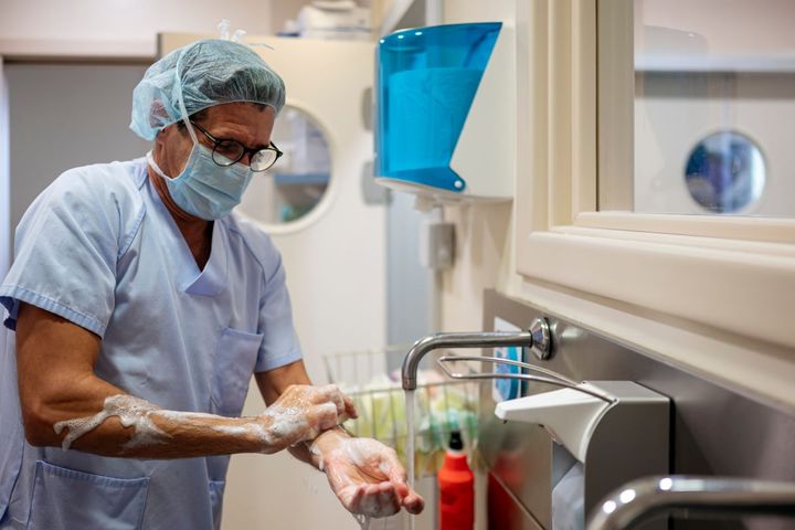 An infection control nurse scrubs up for surgery.