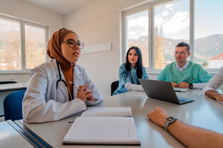 A physician and some nurses gather to discuss new protocols.