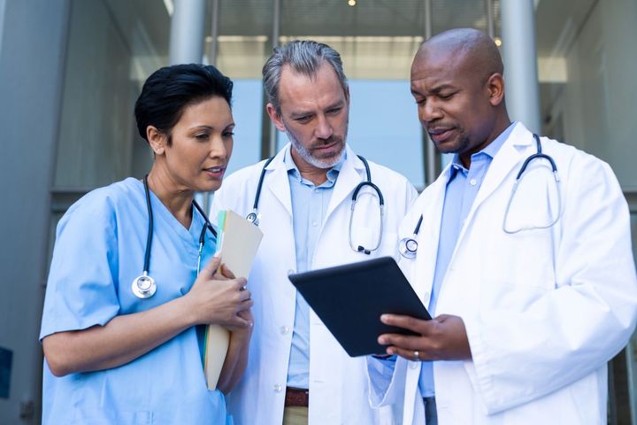 An Iowa nurse talks with two physicians, as they look at a patient's chart.