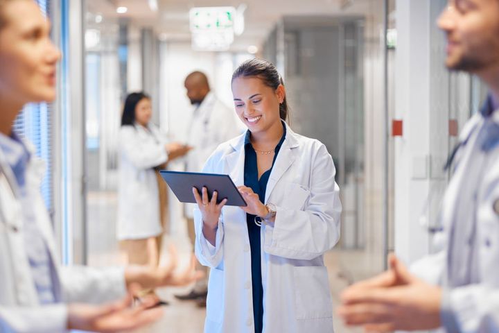 Doctors in a Louisiana medical clinic confer with each other in the hallway, as one looks at a tablet computer.