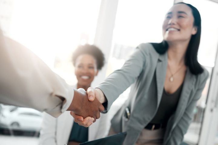 A job candidate shakes the hiring manager's hand before being asked LPN interview questions.