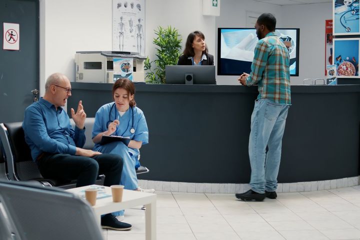 Wide shot showing the waiting room and reception desk of a medical clinic.