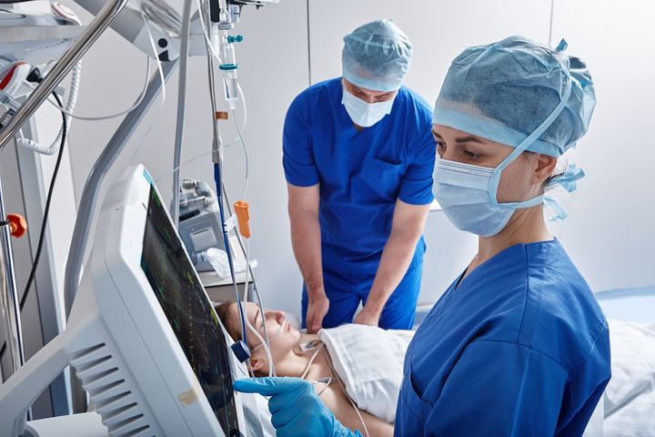 Med surg nurses help a patient after surgery.