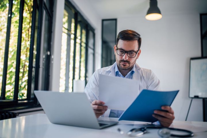 A physician works on his staff's medical credentialing.