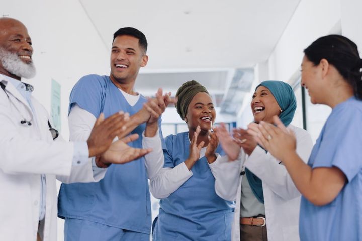 Group of medical staff laughing together in a hallway