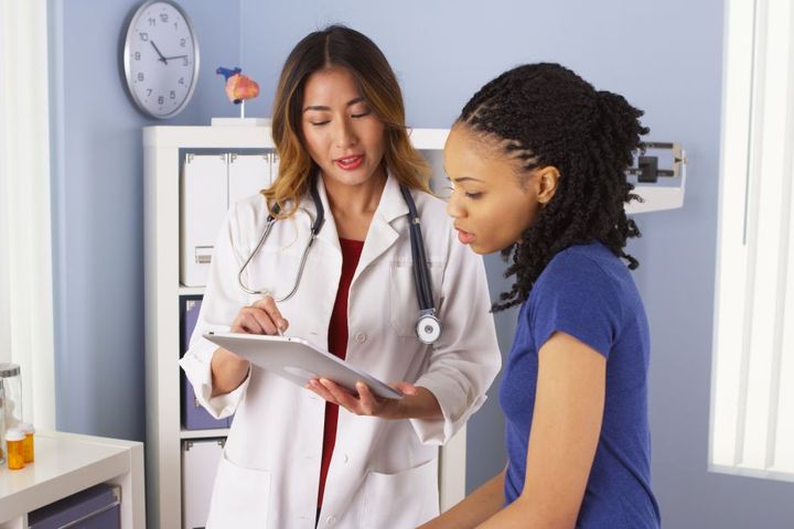 A physician goes over a few things with her patient.