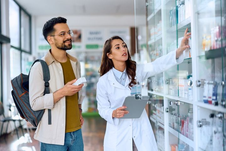 A medication aide assists a patient with his meds.