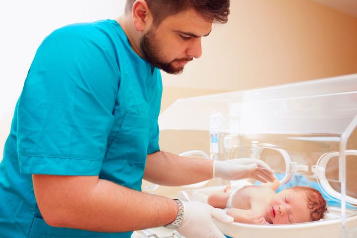 A neonatal nurse checks on one of the infants he's looking after.