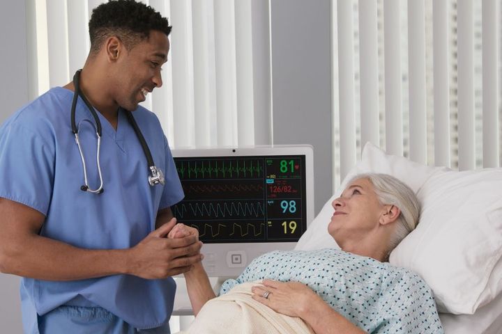 A nurse comforts one of his patients in a Nevada hospital bed.