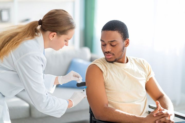 Female clinician giving a patient a vaccination in medical facility