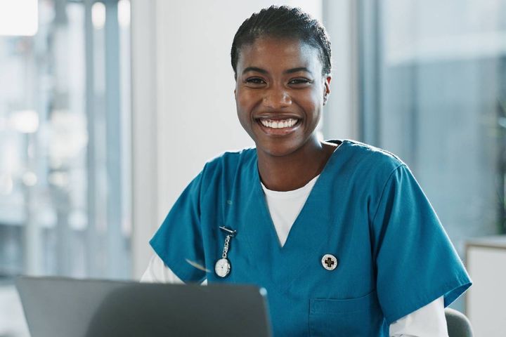 A nurse investigator works on a computer compiling information for an investigation.