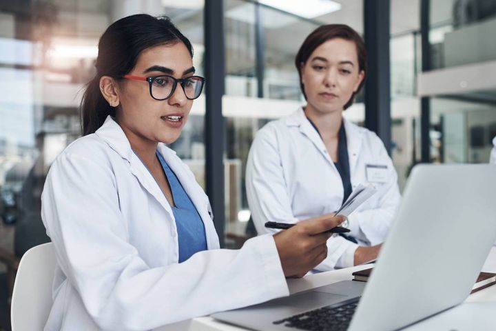 Two healthcare workers discuss the differences between nurse practitioner vs. doctor roles.