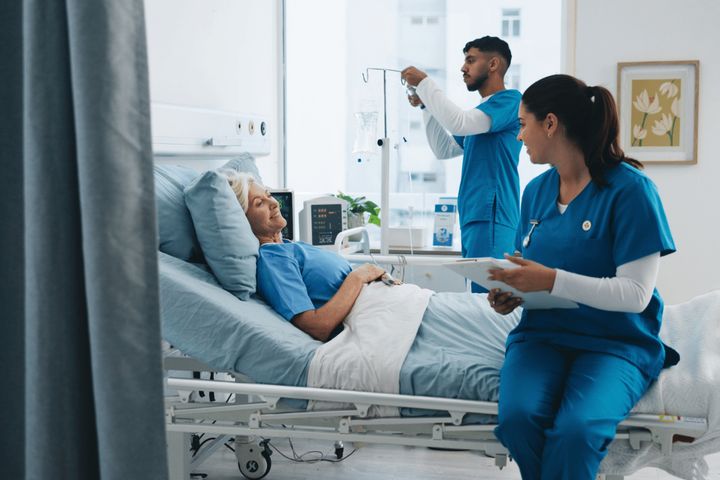 A hospital room where two nurses develop a nurse-patient relationship with an older woman.