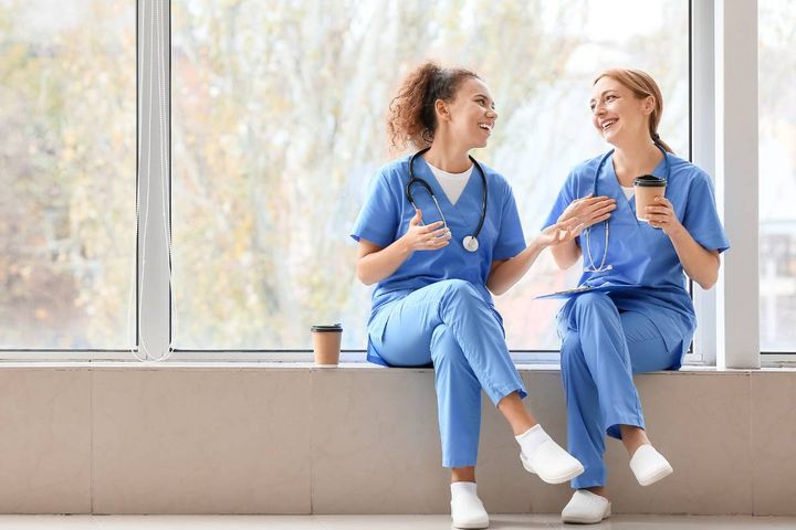 Two nurses enjoy Nurses Week deals of coffee and snacks before their shift.