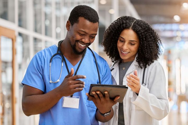 A nurse and a physician check nursing job sites for new recruits.