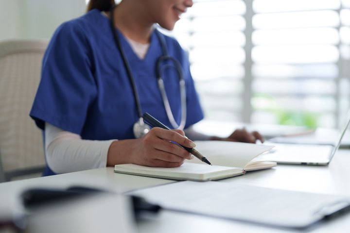 A nurse writes a nursing care plan for pneumonia after a shift.