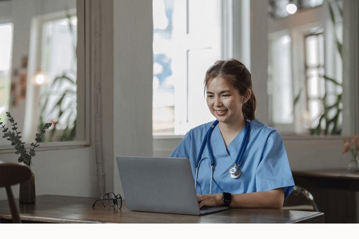 A nurse browses nursing webinars online.