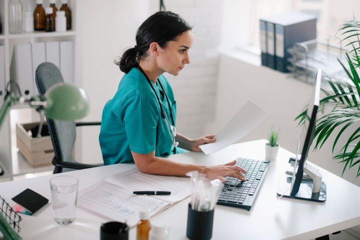 A nurse complete PECOS enrollment on the computer.
