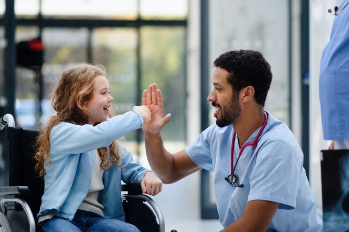 Pediatric nurse giving a high five to a patient