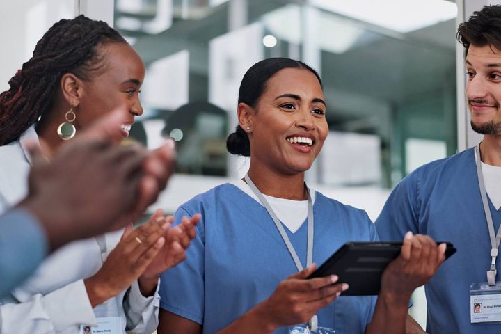 A RN manager answers questions about nursing during a meeting.