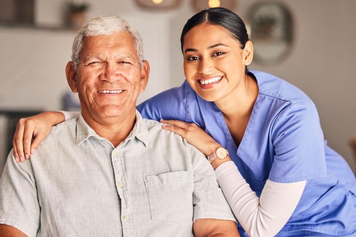 A nurse poses with one of her nursing home residents.