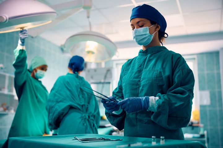 A surgical nurse prepares instruments before a procedure.