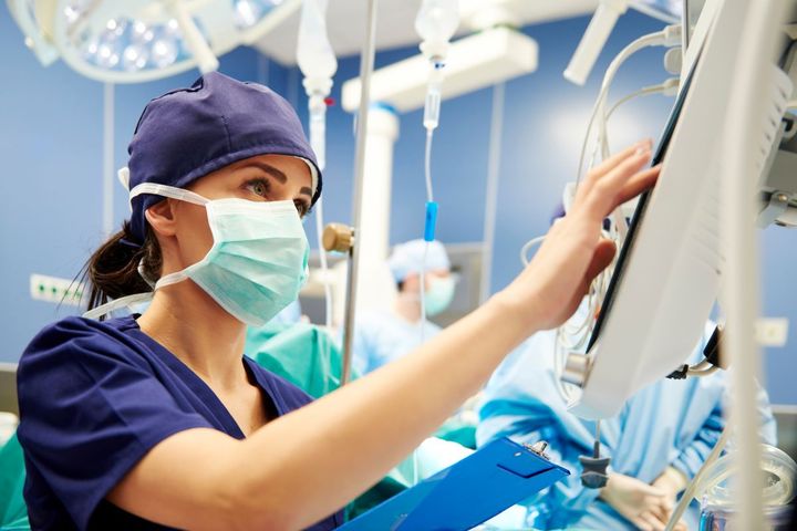 A nurse participates in a surgical time-out procedure.