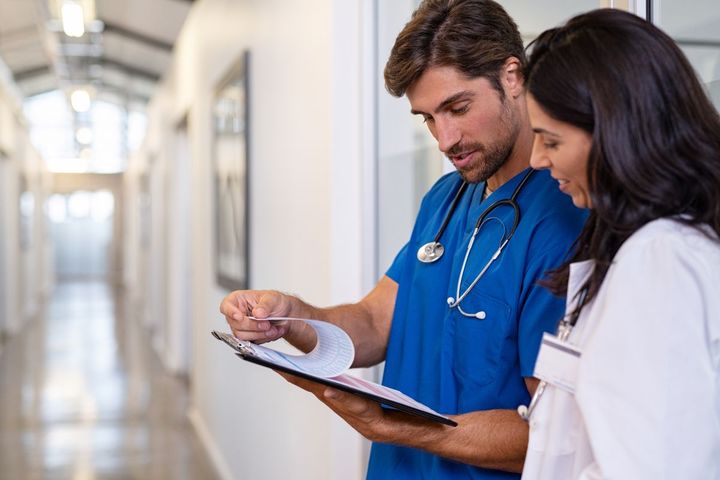 A utilization review nurse shares his findings with a physician.