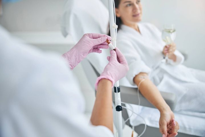 A nurse with VA-BC certification adjusts an IV line.